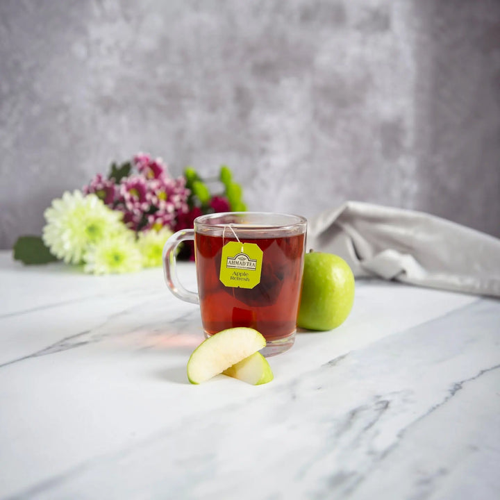Delikatesi i tako to... Ahmad Tea Apple Refresh fruit tea in a glass mug with fresh apple slices and flowers