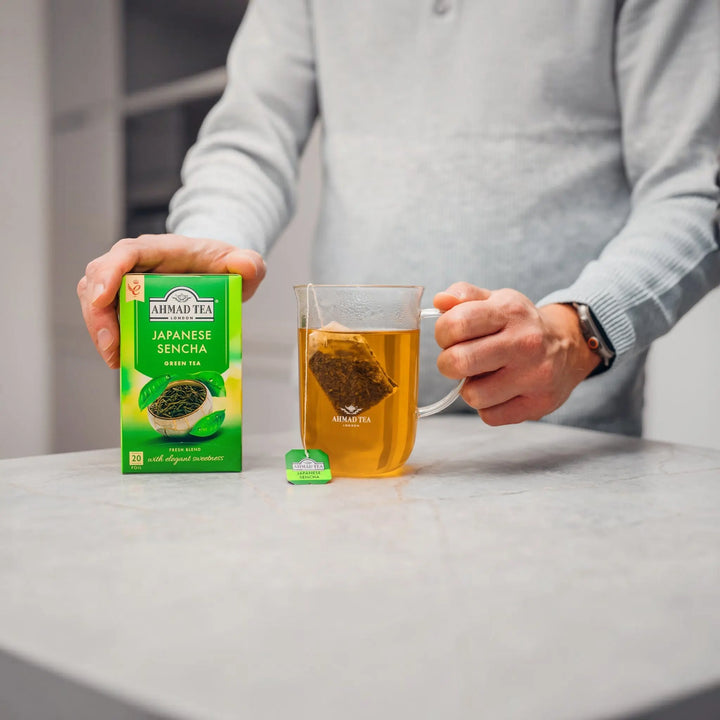 Delikatesi i tako to... Ahmad Japanese Sencha green tea box next to a glass mug with a tea bag in hot water