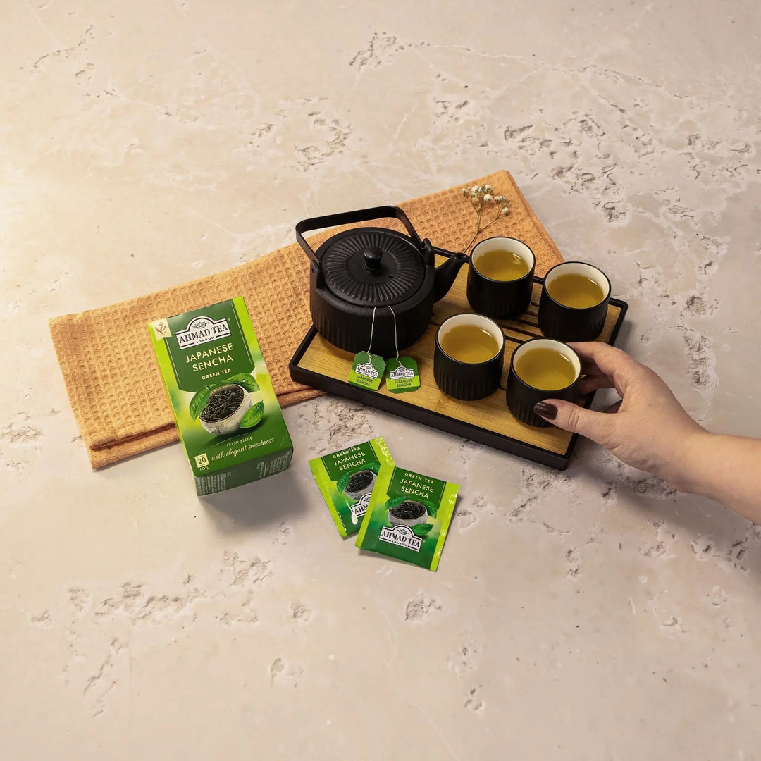 Delikatesi i tako to... Ahmad Tea Japanese Sencha green tea box with tea bags, black teapot, and four cups on a tray.