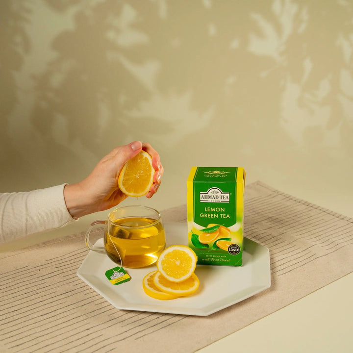 Delikatesi i tako to... Ahmad Tea lemon green tea box with a hand squeezing fresh lemon into a cup of tea.