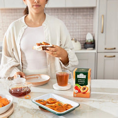Delikatesi i tako to... Ahmad Tea Apricot Sunrise black tea box with a cup of tea and fresh apricots on a kitchen table