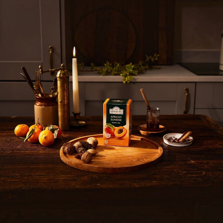 Delikatesi i tako to... Ahmad Tea Apricot Sunrise black tea box with fresh apricots on a rustic wooden table