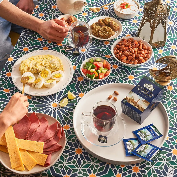 Delikatesi i tako to... Ahmad Tea decaffeinated evening tea box and tea bags served on a patterned table with food