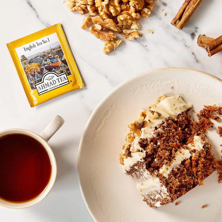 Delikatesi i tako to... Ahmad Tea English Tea No1 sachet with a cup of tea and a slice of carrot cake on a marble table