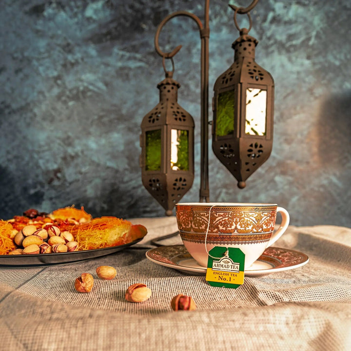 Delikatesi i tako to... Ahmad Tea English Tea No1 teabag in an ornate cup with lanterns and Middle Eastern pastries