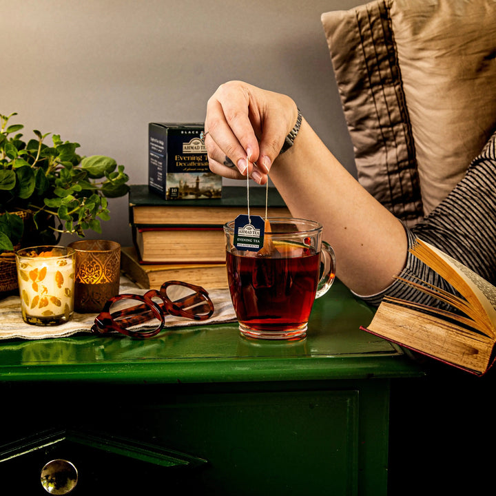 Delikatesi i tako to... Ahmad Tea decaffeinated evening tea bag being dipped into a glass mug for relaxation