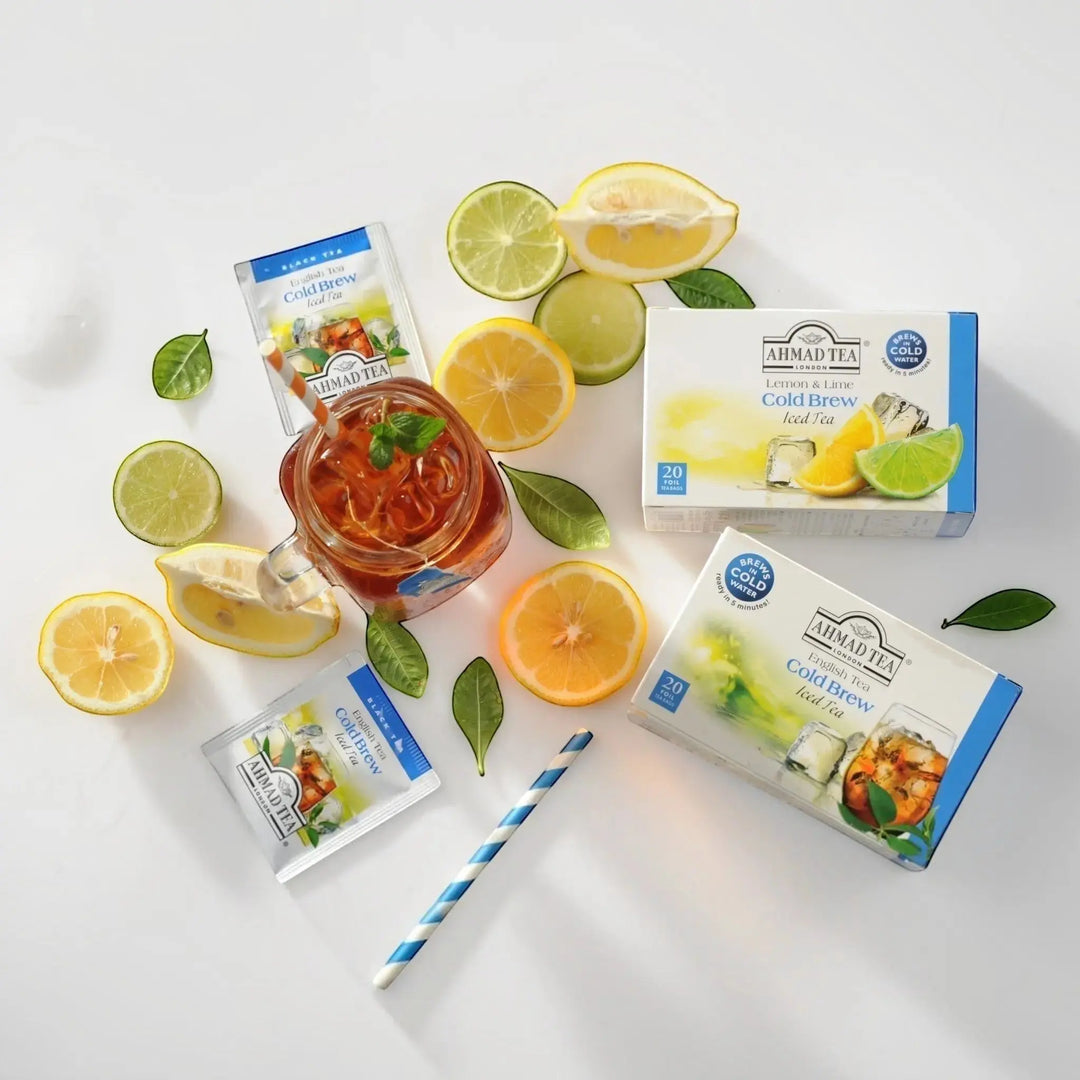 Delikatesi i tako to... Ahmad Tea Lemon & Lime cold brew tea boxes, tea bags, and a glass of iced tea with citrus.