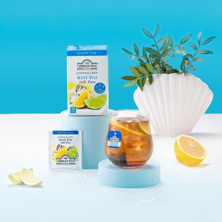 Delikatesi i tako to... Ahmad Tea Lemon & Lime cold brew black tea box, tea bag, and glass of iced tea with citrus.