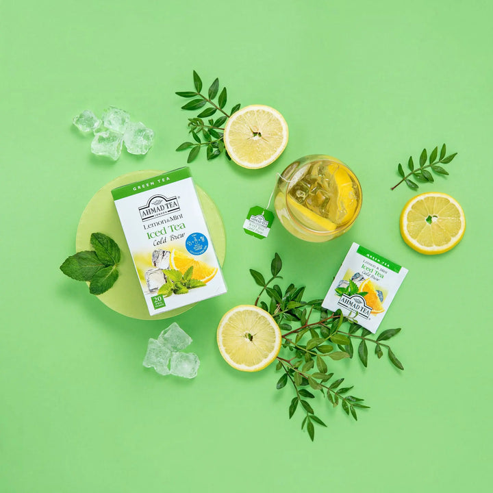 Delikatesi i tako to... Ahmad Tea Lemon & Mint cold brew green tea box with tea bag, ice, and fresh lemon slices.