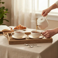 Delikatesi i tako to... Ahmad Tea white porcelain tea set with teapot, two cups, and saucers on a wooden tray