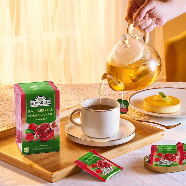 Delikatesi i tako to... Ahmad Tea Raspberry & Pomegranate green tea box with tea being poured into a cup on a tray