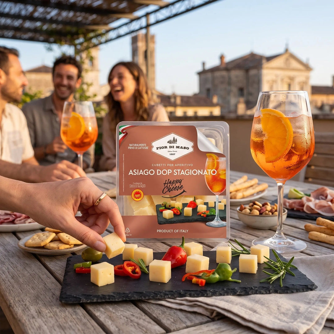 Delikatesi i tako to... Fior di Maso Asiago DOP cheese cubes served on a slate board with peppers and rosemary