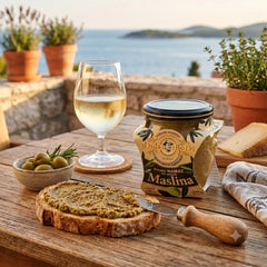 Dida Boža green olive tapenade spread by Delikatesi i tako to... served on rustic bread with wine and cheese.