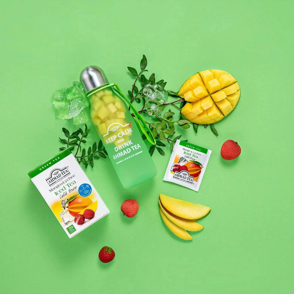 Delikatesi i tako to... Ahmad Tea Mango & Lychee cold brew tea box, tea bag, and bottle with fresh fruit on green