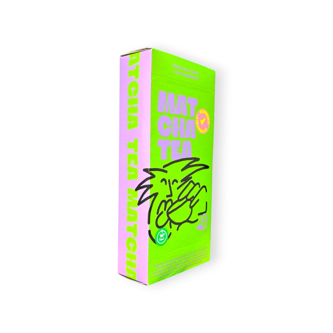Delikatesi i tako to... green box of 10 matcha tea capsules with purple lettering and a cartoon drawing.