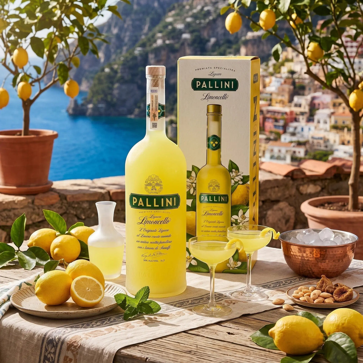 Delikatesi i tako to... Pallini Limoncello 3L bottle with glasses and fresh lemons on a sunny Amalfi coast terrace.