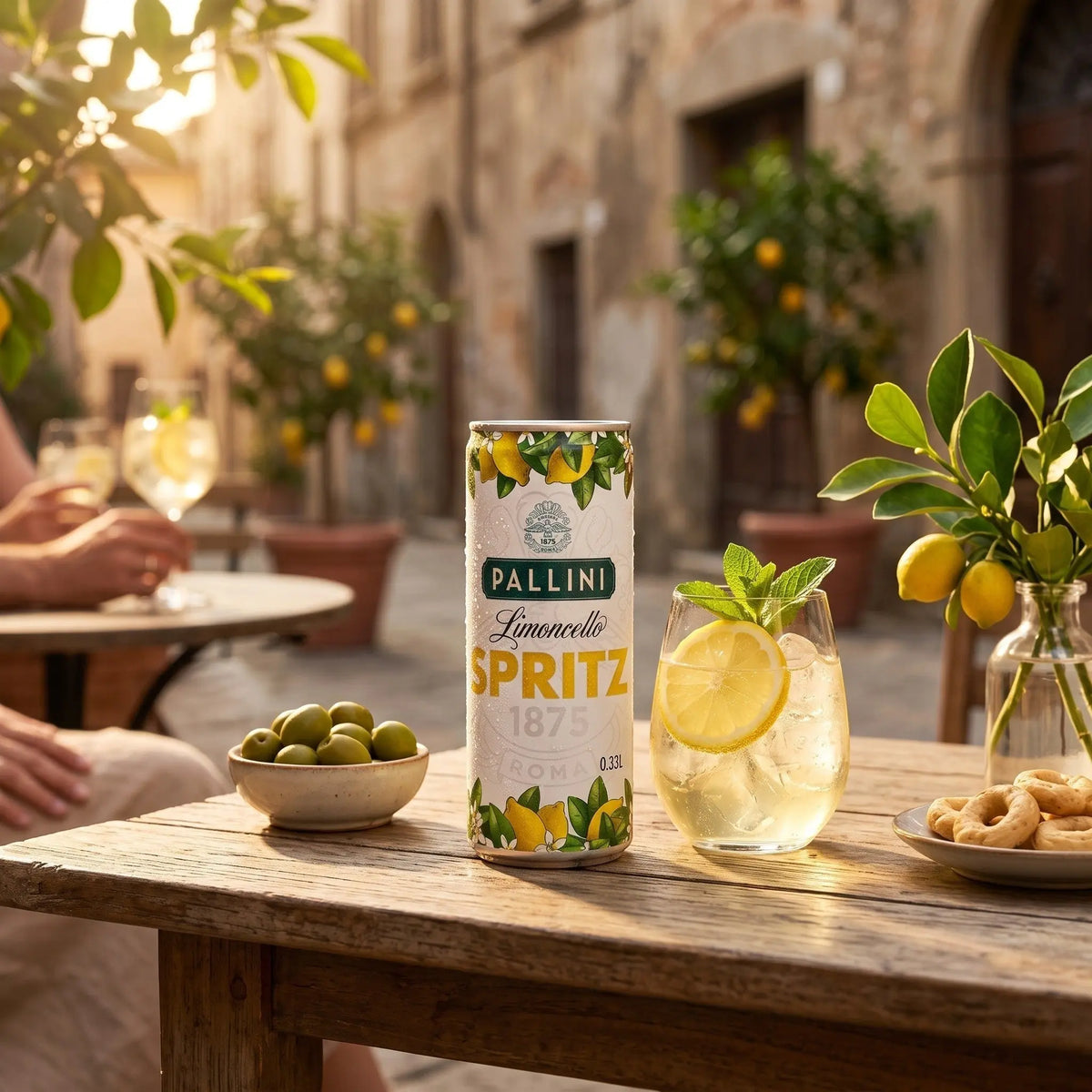 Delikatesi i tako to... Pallini Limoncello Spritz can and glass with lemon slice on a wooden table in an Italian street