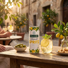 Delikatesi i tako to... Pallini Limoncello Spritz can and glass with lemon slice on a wooden table in an Italian street