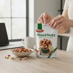Delikatesi i tako to... Pellito mixed nuts with cranberries in a stand-up pouch, held by a person at a desk.