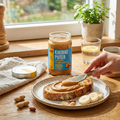 Delikatesi i tako to... Pellito peanut butter spread on toasted bread with banana slices on a wooden table.
