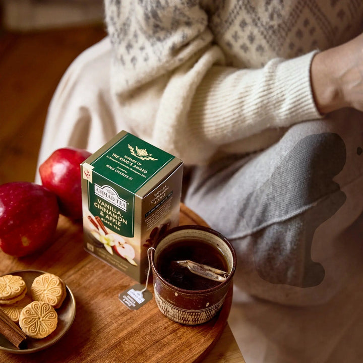 Delikatesi i tako to... Ahmad Tea Vanilla, Cinnamon & Apple tea box with a warm cup of tea, apples, and cookies.