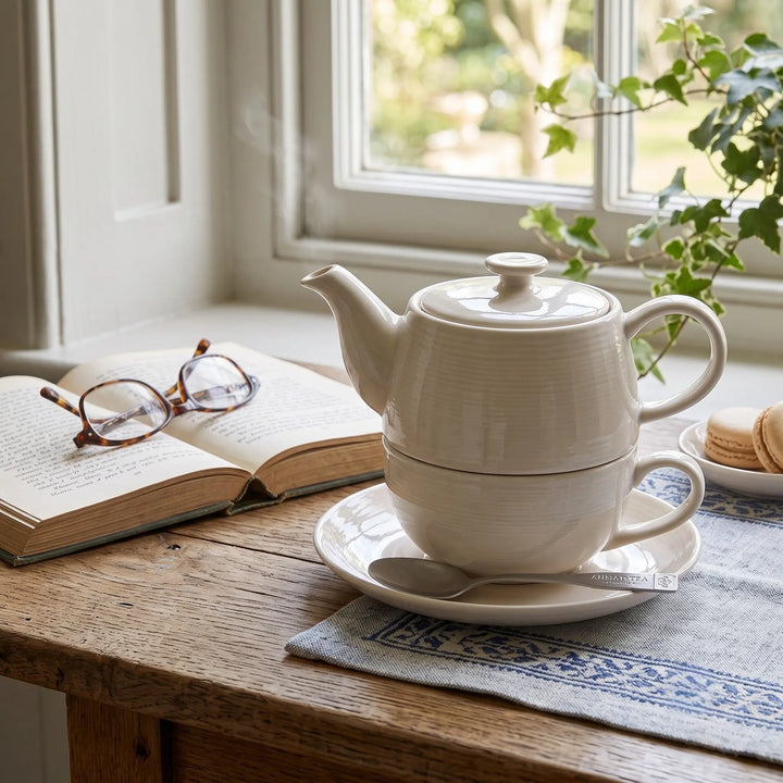 Delikatesi i tako to... Ahmad Tea white ceramic tea for one set with teapot, cup, saucer, and spoon on a wooden table